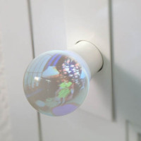 Glass lens doorknob gives preview of room beyond