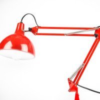 Red 4 bar linkage arm lamp with light shining downwards.