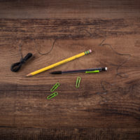 String, pencils, and paperclips on a wooden table.