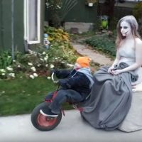 Tricycling “Toddler” Serves as Chauffeur in This Creepy Costume