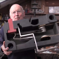 Tim Hunkin holds an oversized cross section of a two-pronged electrical plug
