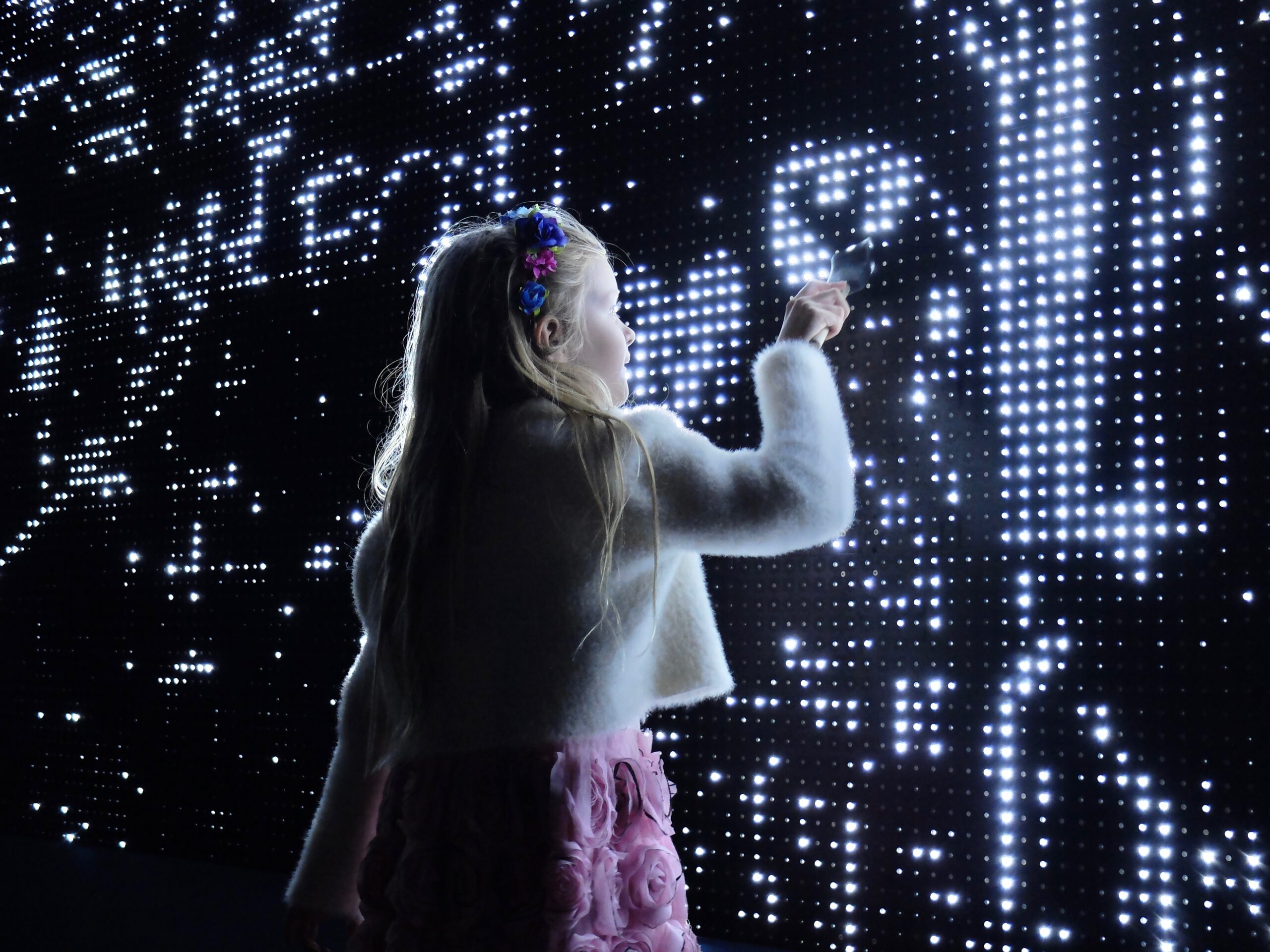 Girl drawing on LED wall with water